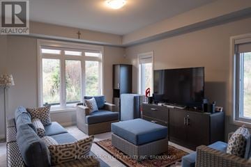 Niagara Falls (Cherrywood) house for rent - A living room with a leopard print chair and a blue ottoman.