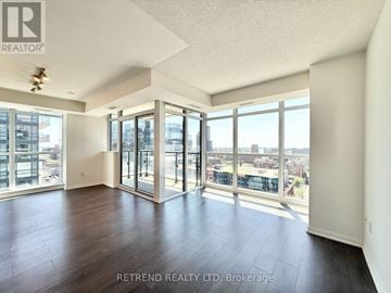 Toronto (Moss Park) condo for rent - A spacious room with a view of the city through large windows.