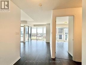 Toronto (Moss Park) condo for rent - A spacious room with a view of the city through large windows.