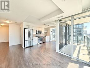 Toronto (Moss Park) condo for rent - A spacious kitchen with stainless steel appliances and a view of the city.