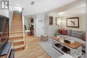 Toronto (Birchcliffe-Cliffside) apartment for rent - A living room with a staircase on the left and a grey couch with red pillows on the right.