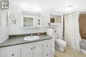 Toronto (Birchcliffe-Cliffside) apartment for rent - A bathroom with a sink, toilet, and mirror.
