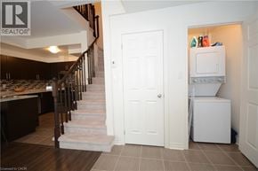 Oakville townhouse for rent - A white door is in a hallway with a staircase on the left.