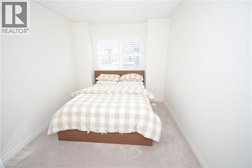 Oakville townhouse for rent - A bedroom with a bed and a window.