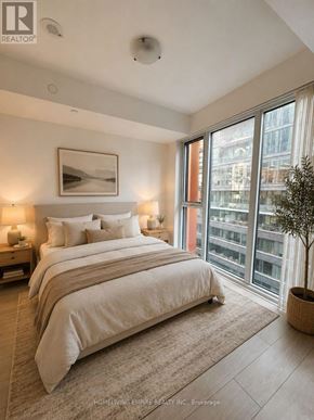 Toronto (Waterfront Communities) condo for rent - A bedroom with a large bed and a view of the city.