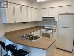 Toronto (Willowdale West) condo for rent - A kitchen with white cabinets and a brown countertop.