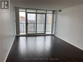 Toronto (Willowdale West) condo for rent - A room with a large window and wooden flooring.