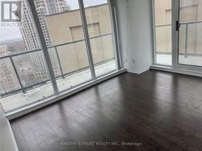 Toronto (Willowdale West) condo for rent - A room with wooden floors and large windows overlooking a cityscape.
