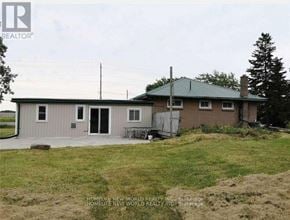 Belleville (Thurlow Ward) apartment for rent - A house with a green roof and a sign that says "REALTOR" in the background.