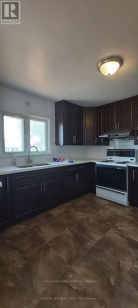 Belleville (Thurlow Ward) apartment for rent - A kitchen with dark brown cabinets and a white oven.