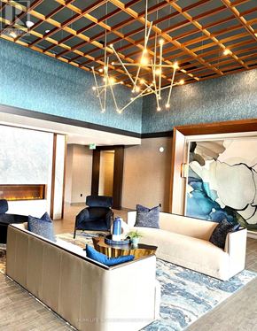 Hamilton (Waterdown) condo for rent - A modern living room with a large sofa, a coffee table, and a fireplace.
