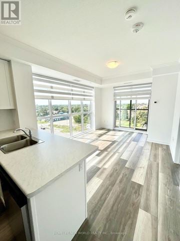 Hamilton (Waterdown) condo for rent - A modern kitchen with white cabinets and a wooden floor.