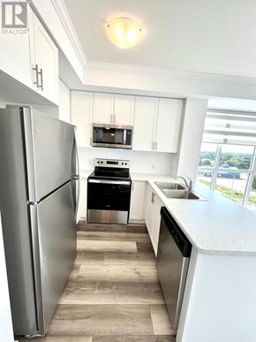 Hamilton (Waterdown) condo for rent - A kitchen with a refrigerator, oven, microwave, sink and cabinets.