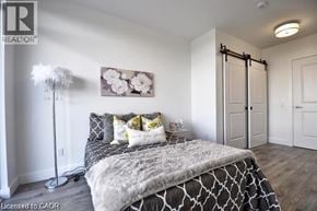 Cambridge condo for rent - A bedroom with a bed, a chandelier, and a painting on the wall.