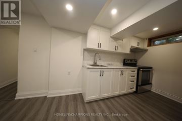 Toronto (Bendale) apartment for rent - A kitchen with white cabinets and a wooden floor.