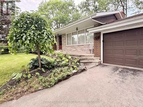 Pelham (Fonthill) apartment for rent - A house with a brown garage door and a tree in front of it.