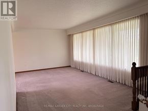 Pelham (Fonthill) apartment for rent - A room with a carpeted floor and a window with curtains.