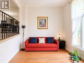 Markham (Bullock) townhouse for rent - A red couch with blue pillows sits in a room with a wooden floor and a painting on the wall.