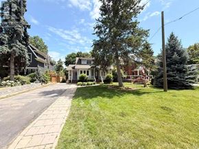 Oakville (Oo Old Oakville) apartment for rent - A residential street with houses on both sides and a clear blue sky.