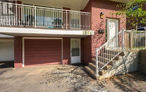 Mississauga (Erindale) apartment for rent - A red brick building with a white door and a balcony with a metal railing.