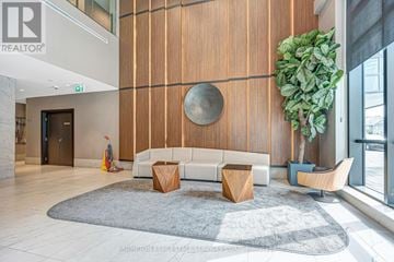 Mississauga (Hurontario) condo for rent - A modern living room with a white couch and a large round mirror on the wall.