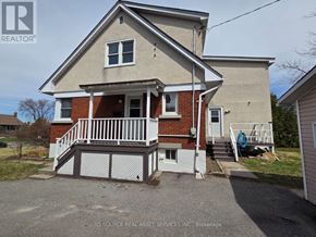 Ottawa apartment for rent - A two-story house with a red brick exterior and a white porch.
