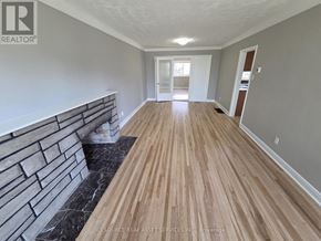 Ottawa apartment for rent - A long hallway with wooden floors and a brick wall on the side.