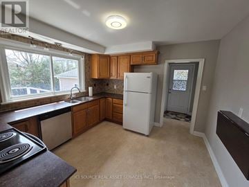 Ottawa apartment for rent - A kitchen with a white fridge and wooden cabinets.