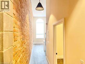 Simcoe apartment for rent - A hallway with a brick wall on the left and a door on the right.