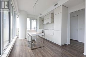 Toronto (Church-Yonge Corridor) condo for rent - A modern kitchen with white cabinets and a bar area.