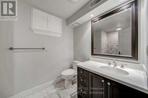 Toronto (Forest Hill South) triplex for rent - A bathroom with a toilet, sink, and mirror.