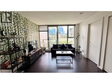 Vancouver apartment for rent - A living room with a black couch and a patterned wallpaper.
