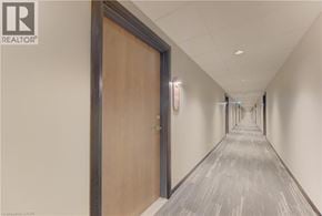 Kitchener condo for rent - A long hallway with a wooden door on the left.