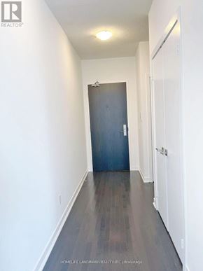 Toronto (Bay Street Corridor) condo for rent - A hallway with a dark door and white walls.