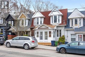 Toronto (Blake-Jones) townhouse for rent - A silver SUV is parked in front of a house with a blue car parked in front of it.