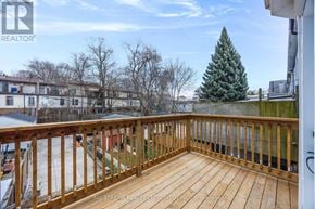 Toronto (Blake-Jones) townhouse for rent - A wooden deck with a railing and a tree in the background.