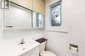 Toronto (Blake-Jones) townhouse for rent - A white bathroom with a toilet, sink, and mirror.