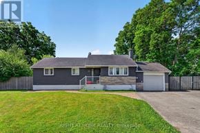 Ottawa apartment for rent - A house with a grey roof and a white garage door is for sale.