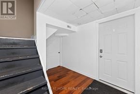 Ottawa apartment for rent - A room with a white door and a staircase.