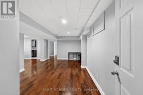 Ottawa apartment for rent - A spacious room with wooden floors and white walls, with a door on the right side.