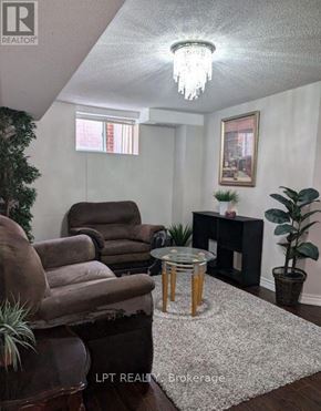 Vaughan (Maple) apartment for rent - A living room with a brown chair, a glass table, and a potted plant.