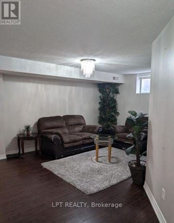 Vaughan (Maple) apartment for rent - A living room with a brown couch and a small table.