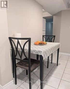 Vaughan (Maple) apartment for rent - A dining table with a white tablecloth and a chair in a room.