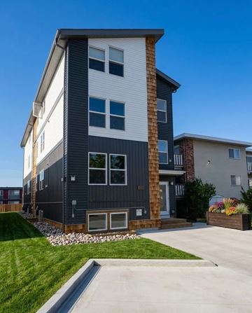 Edmonton apartment for rent - A modern two-story house with a combination of white and dark grey exterior.