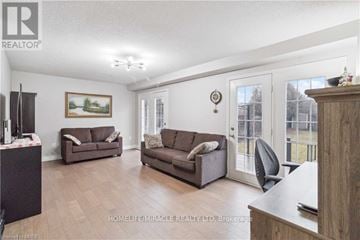 Burlington (Orchard) apartment for rent - A living room with a brown couch and a painting of a tree.