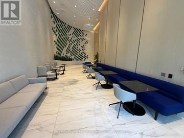 Mississauga (Port Credit) condo for rent - A white and blue lounge area with a black table and chairs.