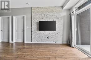 Burlington (Uptown) condo for rent - A room with a flat screen TV mounted on a brick wall.