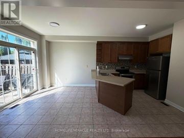 Brampton (Madoc) apartment for rent - A kitchen area with a refrigerator, microwave, and cabinets.
