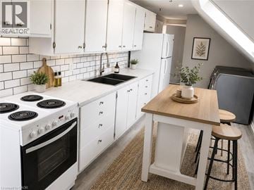 Waterloo apartment for rent - A kitchen with white cabinets and a black stove top.
