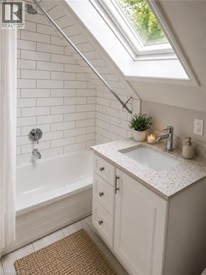 Waterloo apartment for rent - A white bathroom with a skylight and a white tub.